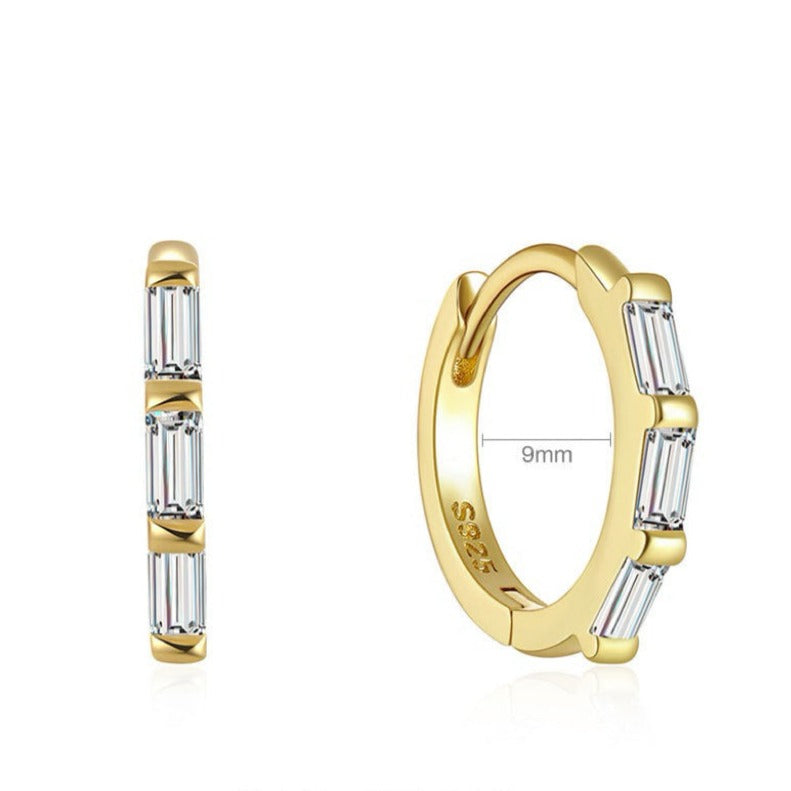 The elegant curve of this hoop earring delicately frames the lobe, complemented by a sparkling cluster of baguette-style cubic zirconia. An absolute essential in any jewelry collection  Materials: High Quality Solid 925 Sterling Silver 5A Cubic Zirconia 18K Gold /White Gold Plating