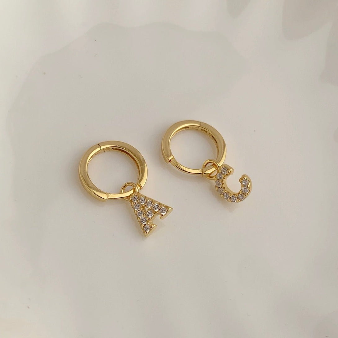 Letter and initial jewelry is a big trend right now. These Initial Hoop Earrings give any outfit a fashionable, contemporary look. You can personalize the earrings by choosing the stylish letter charms you want.  Materials: High Quality Solid &nbsp;925 Sterling Silver 5A Cubic Zirconia White Gold Plating